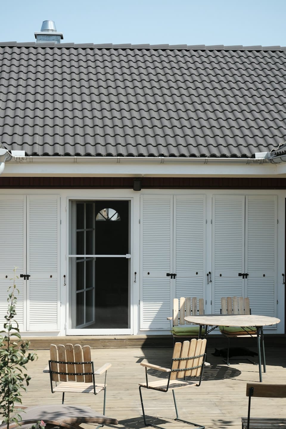 Casa moderna con terrazza in legno e mobili da esterno.