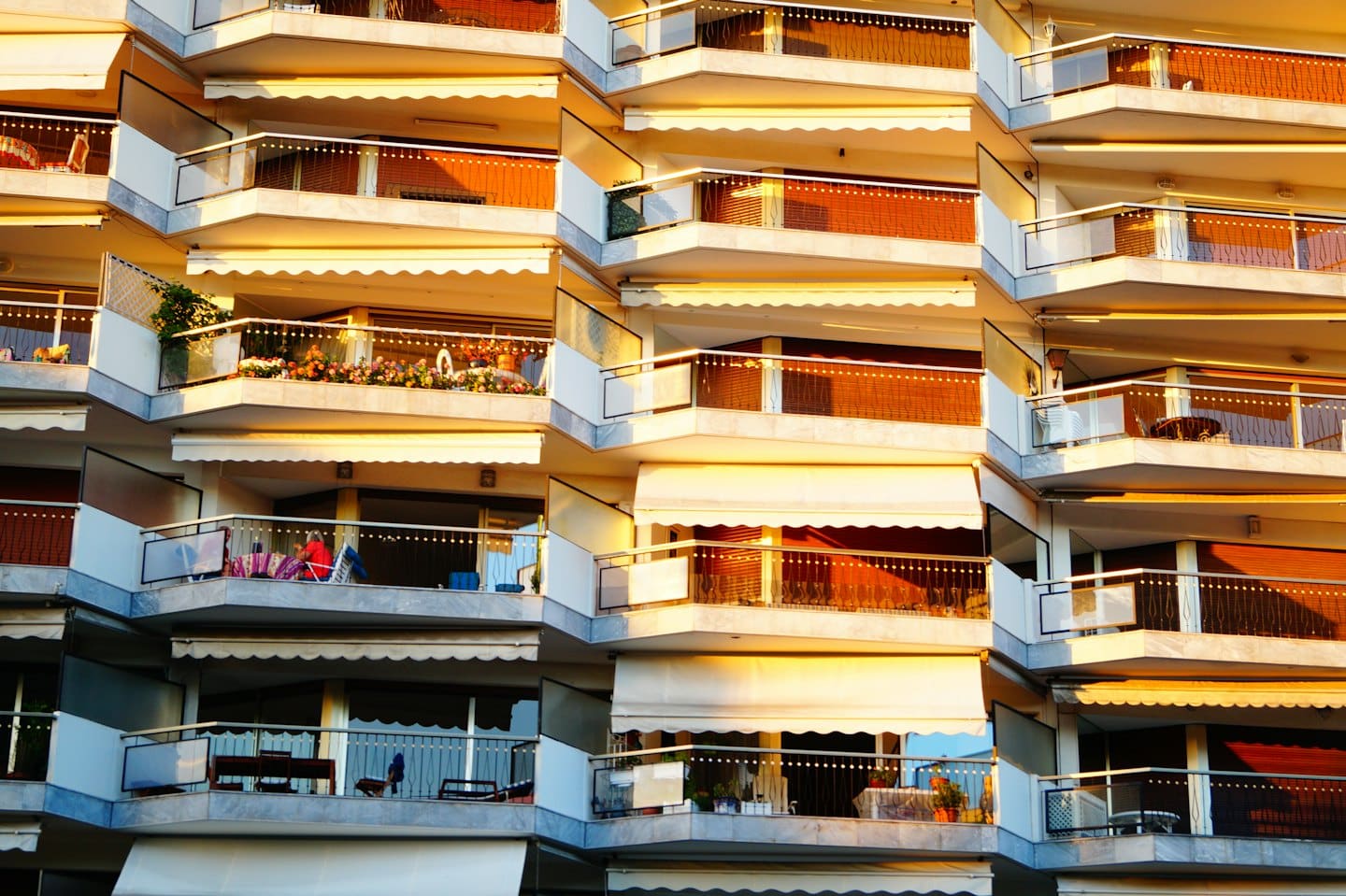 Moderno condominio con balconi e tende da sole bianche a scomparsa.